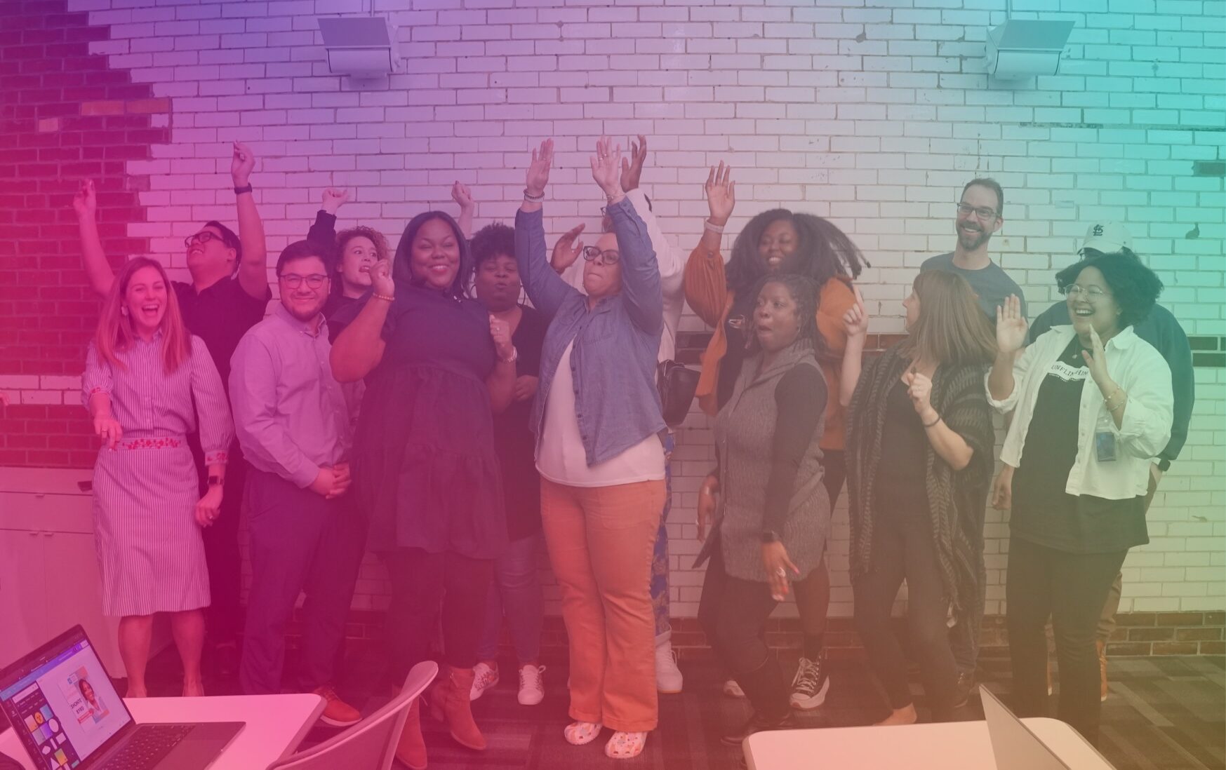 Jumping, cheering board members with a few staff members, with a rainbow overlay. The Forward Through Ferguson board members are racially diverse.